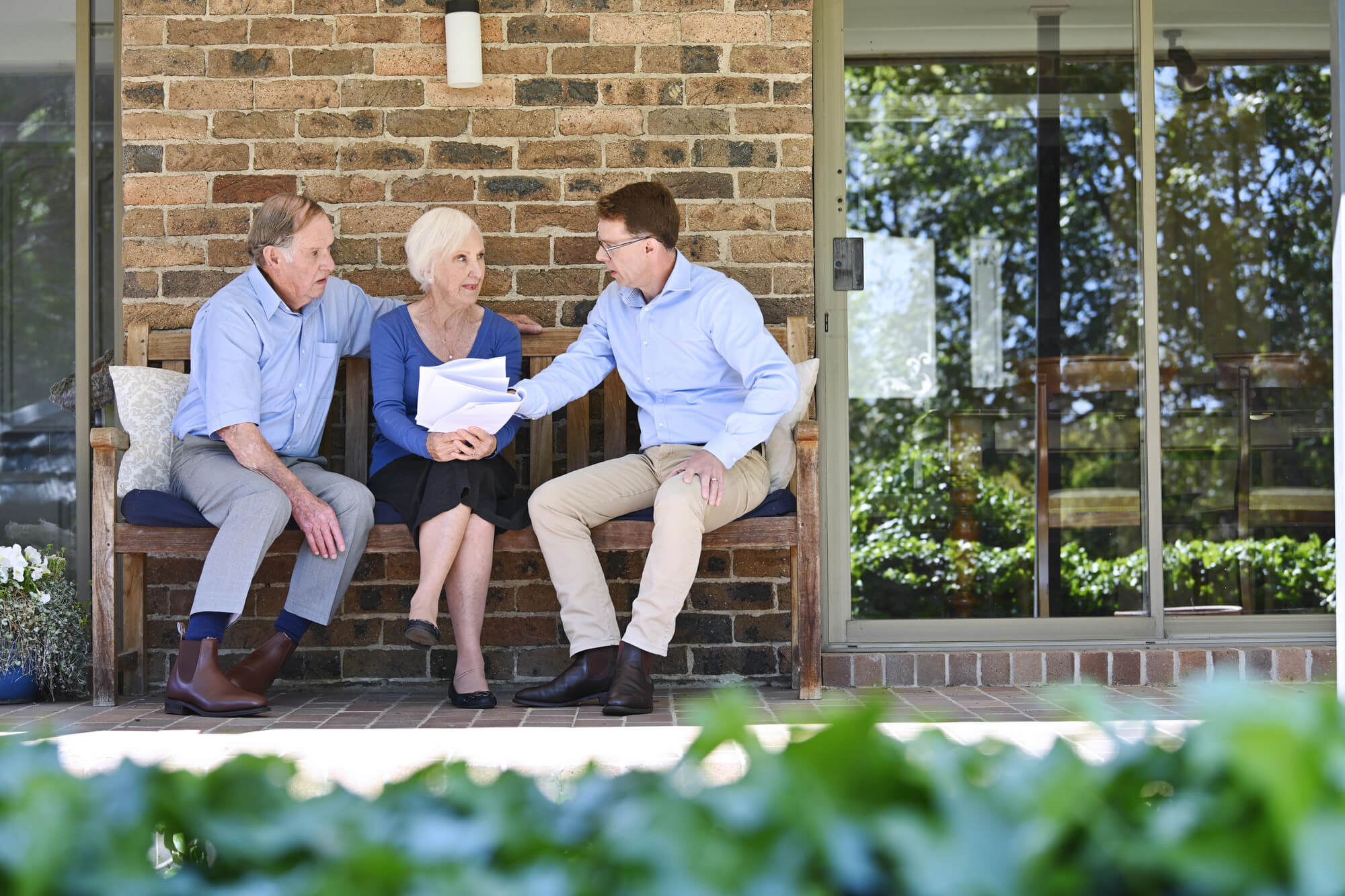 Malcolm from Salvos Funerals talking with an older couple outside their home