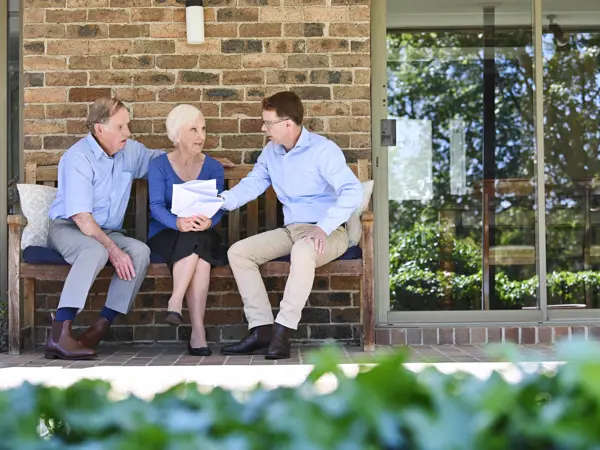 Malcolm from Salvos Funerals talking with an older couple outside their home