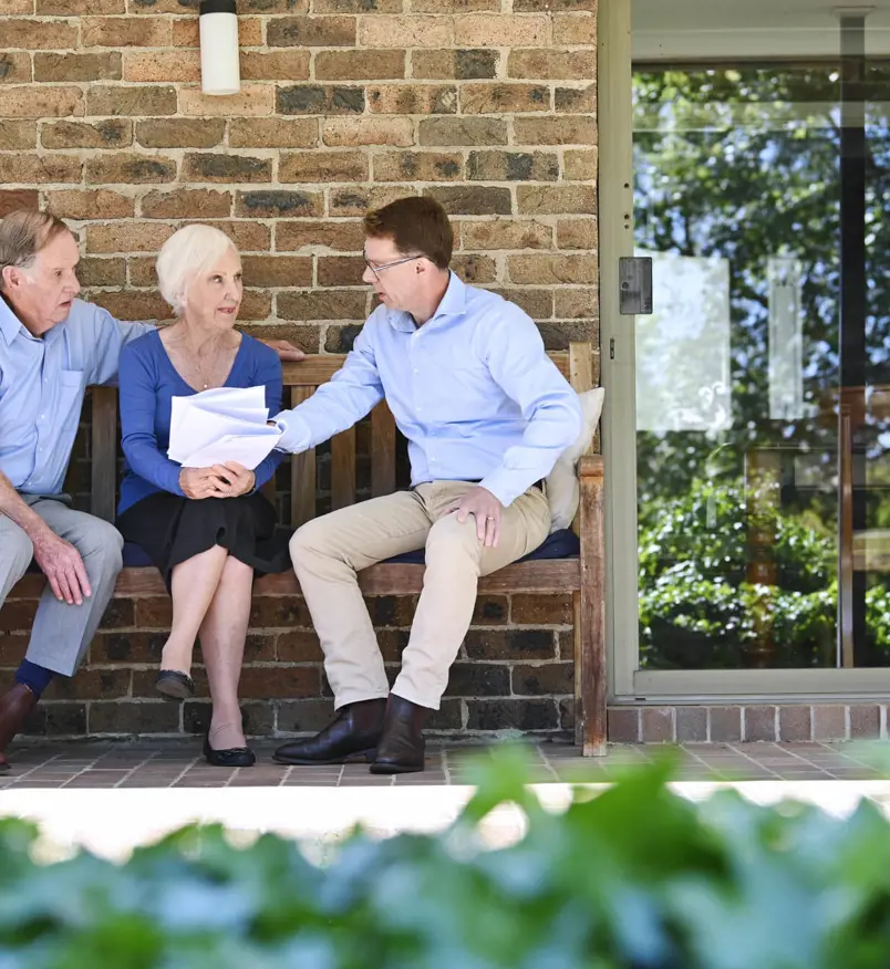 Malcolm from Salvos Funerals talking with an older couple outside their home