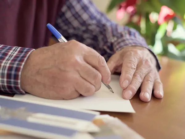 Person writing a sympathy card by hand