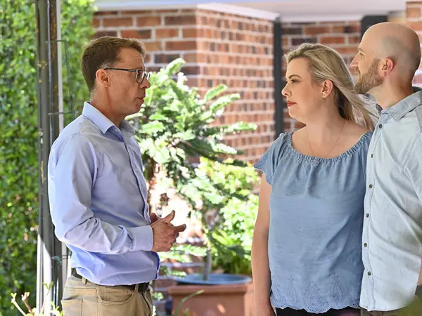 Couple speaking with a funeral planner outside their home